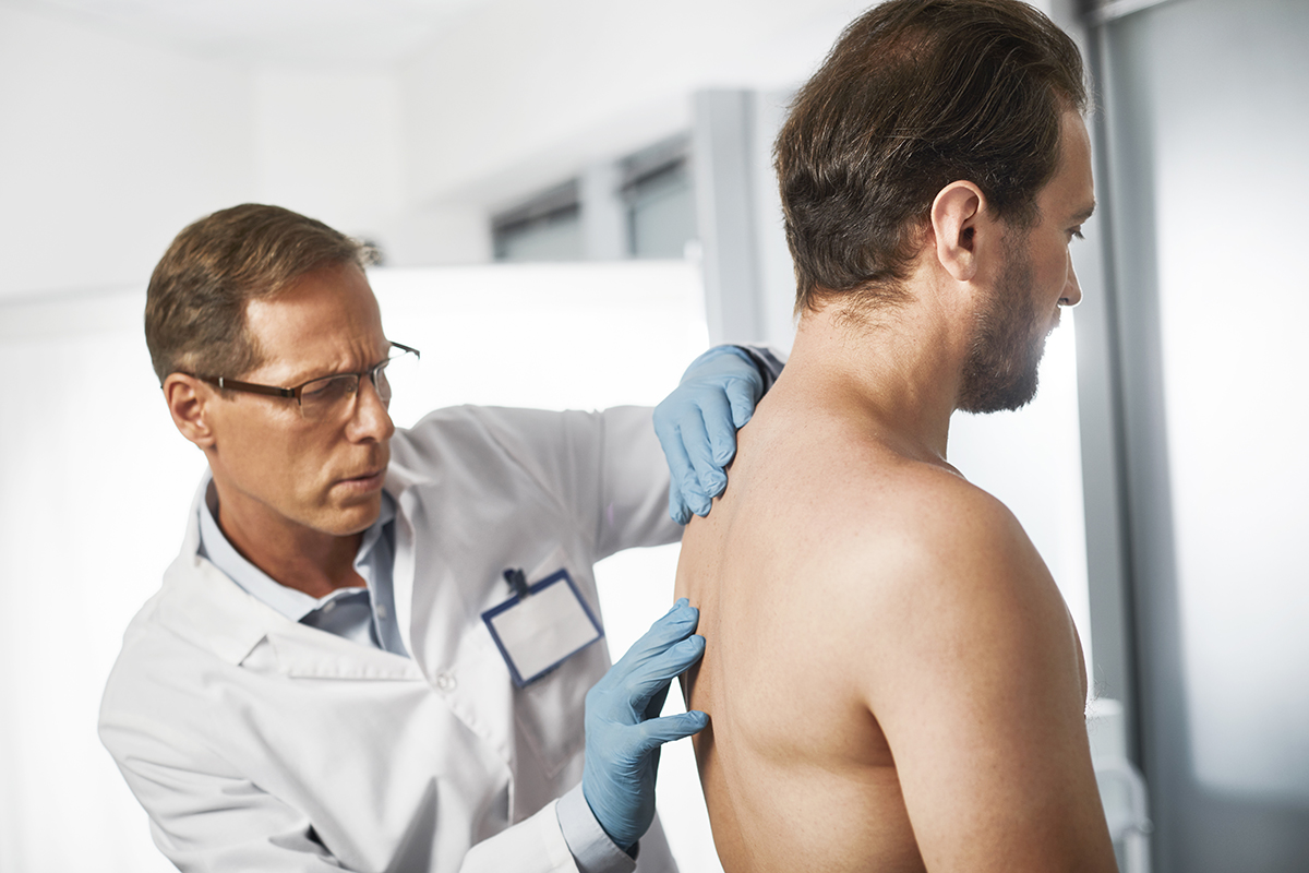 Photo: Doctor examining a patient's back